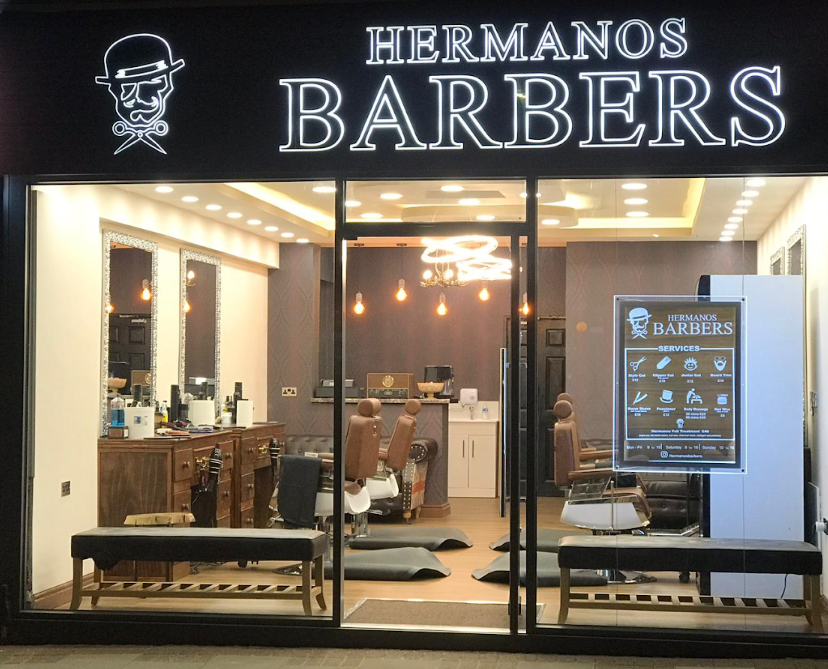 Hermanos Barbers shopfront at night