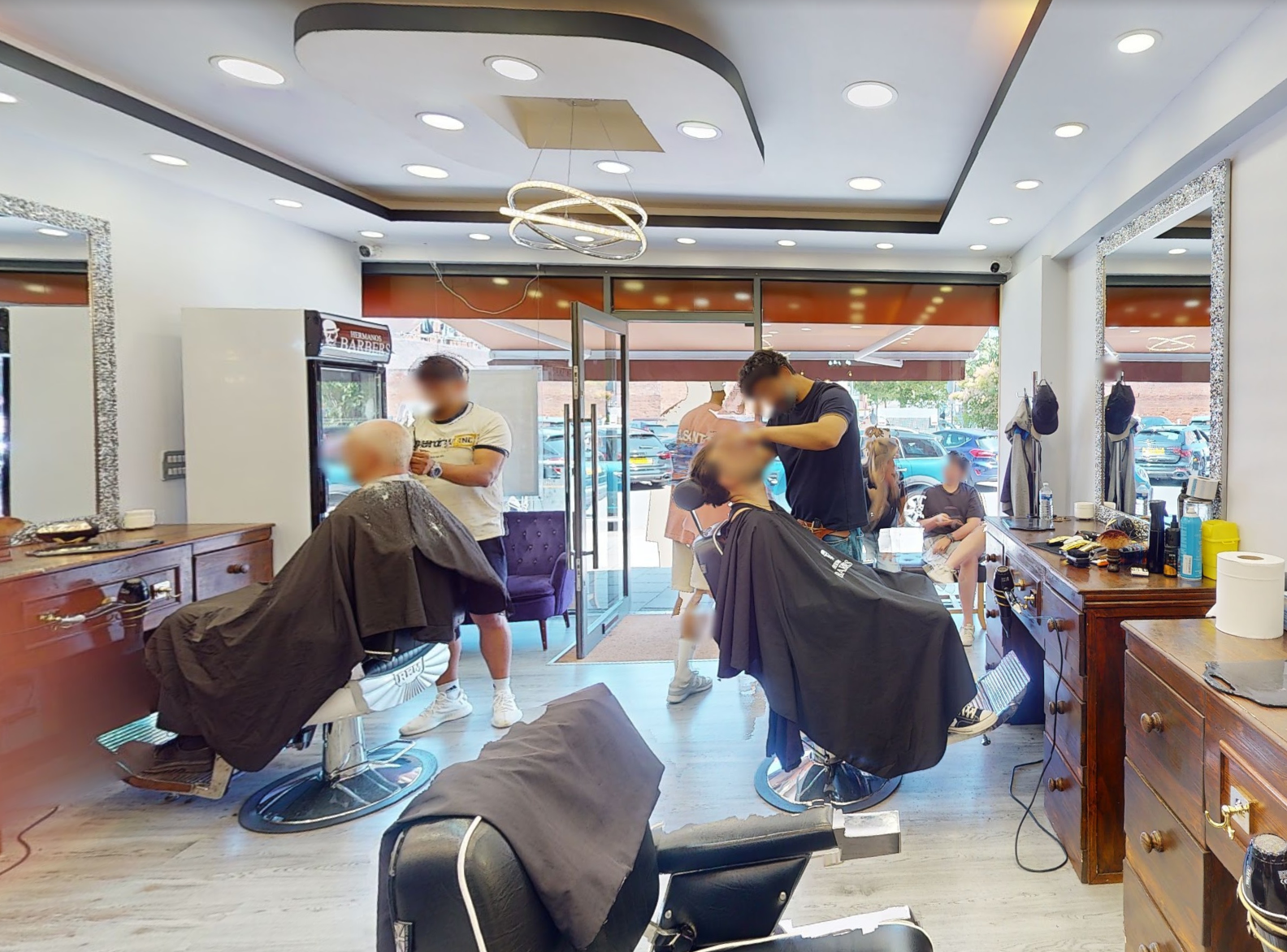 Busy interior of Hermanos Barbers with barbers cutting hair